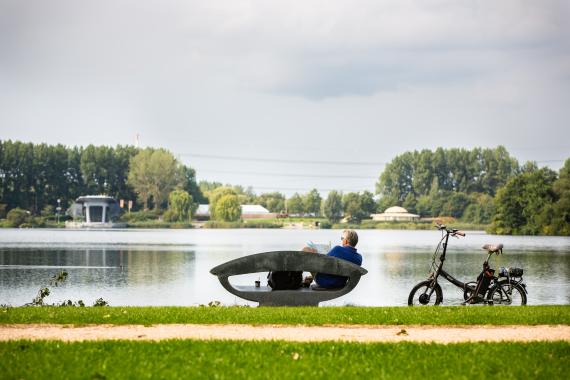 Visitor sitting on a couch, enjoying the recreational area Toolenburgse Plas in Amsterdam Airport City